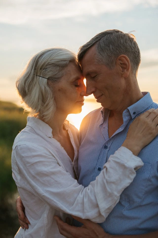 a romantic couple pressing foreheads together in the morning light