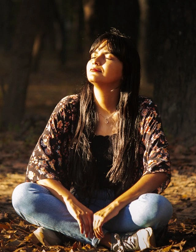 a woman savouring sunshine in nature